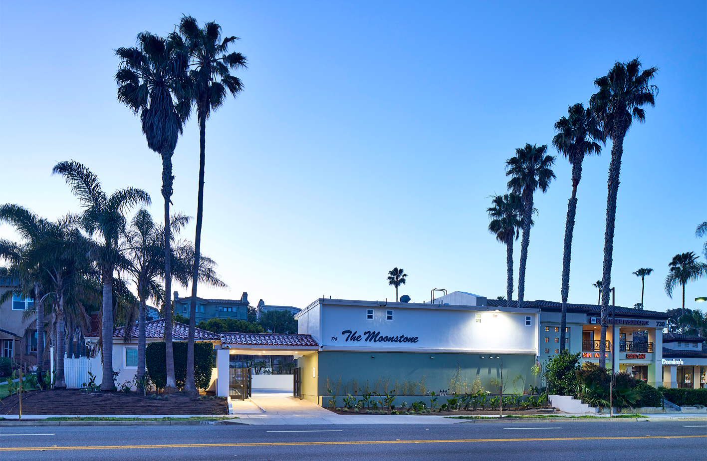 street view of front of The Moonstone, a renovated motel, with palm trees on either side